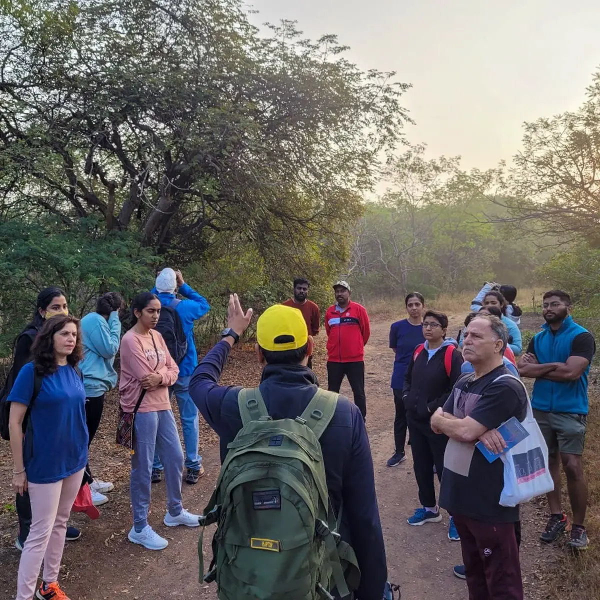 Volunteer briefing a trail group in the woods